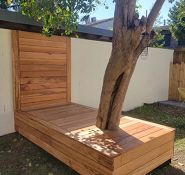 Aménagement de jardin sur mesure à Bordeaux avec terrasse et banc en bois intégré autour d'un arbre