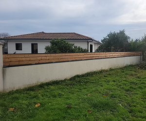 Clôture bois posée sur muret pour délimiter un jardin en Gironde