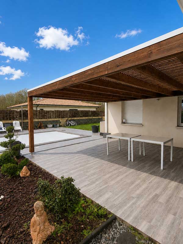 Vue sous pergola en bois avec toiture claire-voie et terrasse en bois