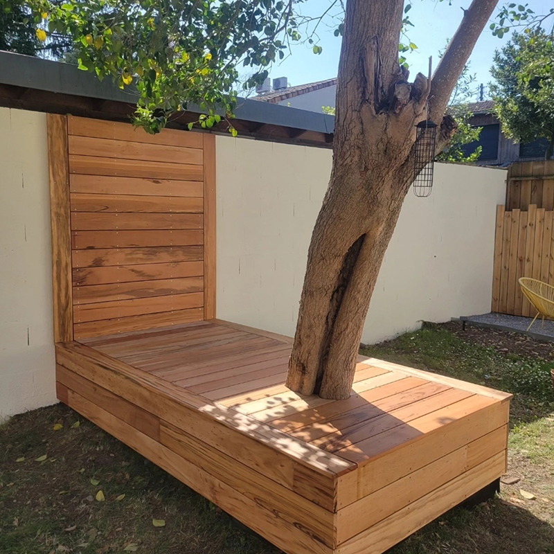 Coin détente en terrasse bois Tigerwood avec intégration d'un arbre dans un jardin à Bordeaux réalisé par Wood Concept 33