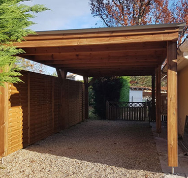 Carport en bois sur mesure protégeant un espace de stationnement extérieur